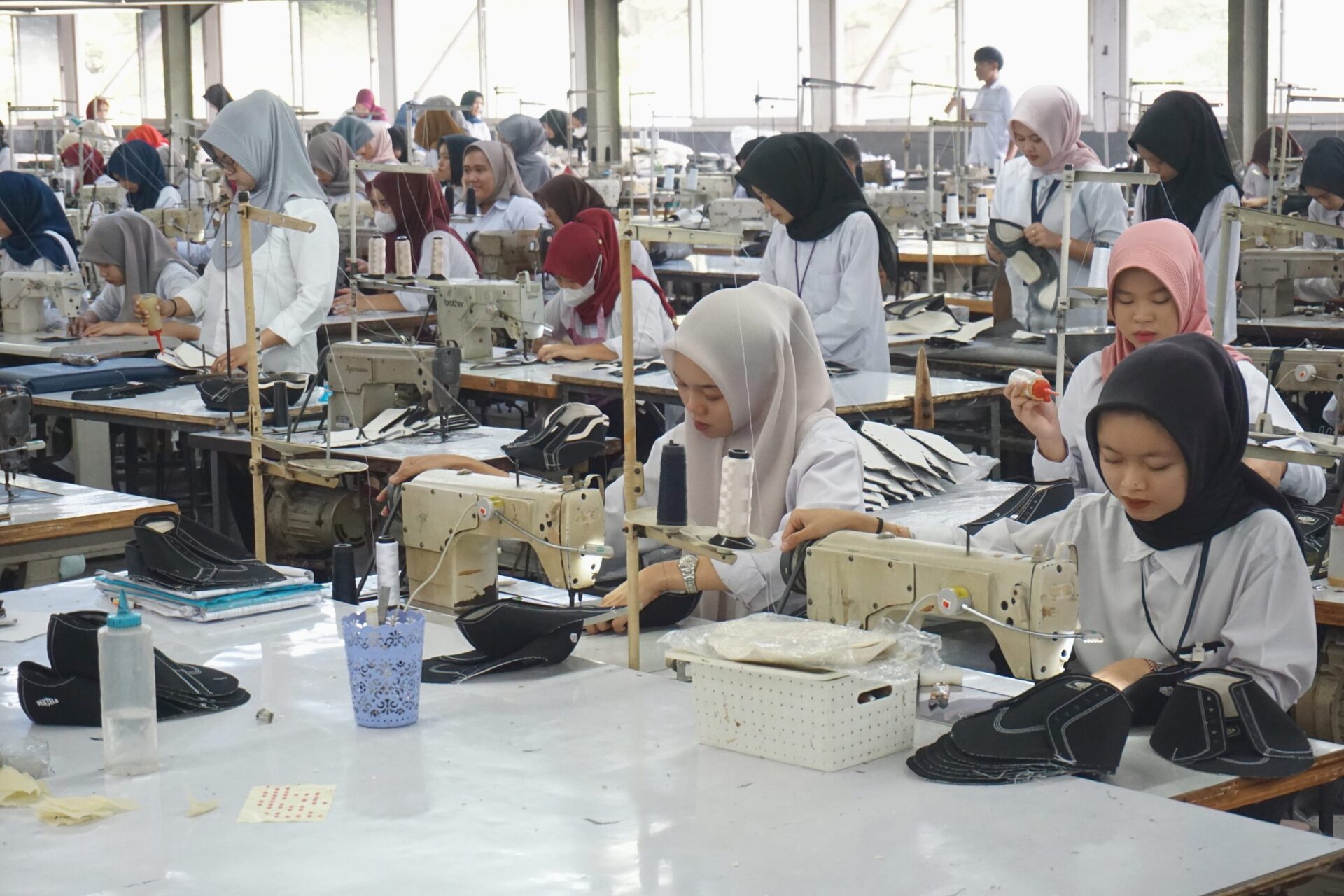 Penjahit di lini jahit bagian atas sepatu